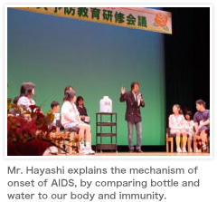Mr. Hayashi explains the mechanism of onset of AIDS, by comparing bottle and water to our body and immunity.